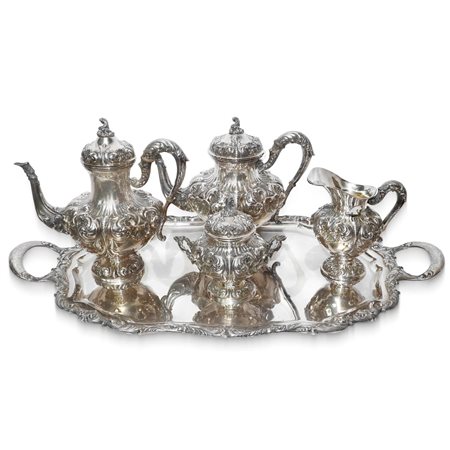 Servizio in argento composto da vassoio, teiera, caffettiera, lattiera in argento sbalzato e bulinato con decorazione di foglie e conchiglie
