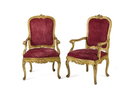 Coppia di poltrone di forma mossa in legno intagliato e dorato, braccioli e pie