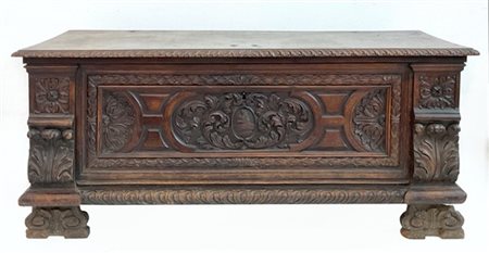 Cassapanca in noce intagliato con fronte decorato da volute e medaglione con st