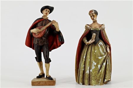 Coppia di piccole sculture in legno intagliato, dipinto e laccato raffiguranti