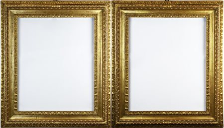 Coppia di antiche cornici in legno intagliato e dorato a doppio ordine con moti