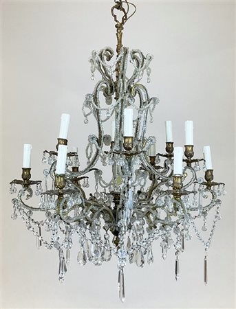 Antico lampadario a dodici luci in metallo dorato con bracci a volute decorati