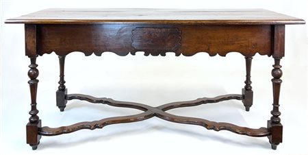 Tavolo in noce con gambe tornite a rocchetto raccordate da traverse mistilinee