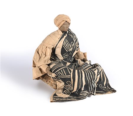 Figura di orientale seduto volto e arti in terracotta grigia, turbante e...