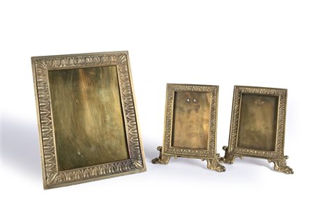 Tre cornici da tavolo in ottone la coppia con palmette e piedi ferini la...