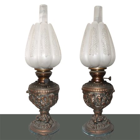 Coppia di lumi a petrolio con base in ottone sbalzato a rilievo con motivi floreali, 19° Secol
