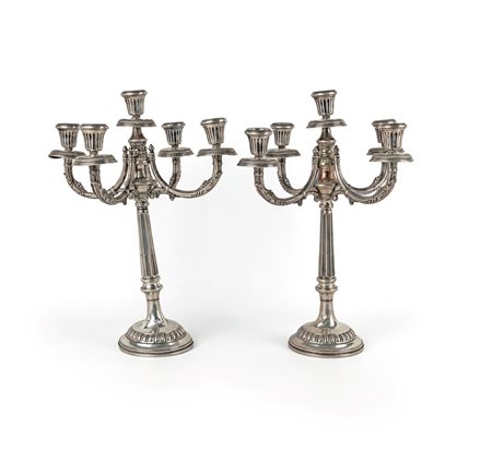 Coppia di candelabri a cinque luci stelo in forma di colonna percorsa da...