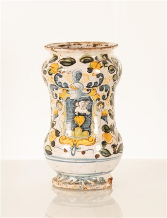 Albarello da farmacia decorato con due serti fioriti stante ad incorniciare un blasone sorretto da due angeli