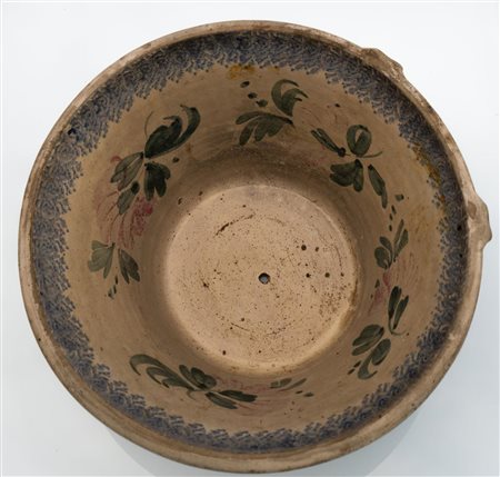 Grande catino monoansato con foro centrale successivo. Decoro interno a stampino e floreale.    Manifattura di Castelli della fine del XIX secolo