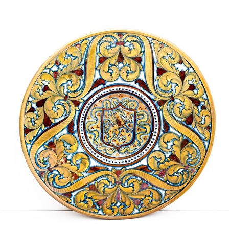 Piatto in maiolica decorata a lustro metallico con decoro di girali fogliati nella tesa e grifo rampante racchiuso in uno scudo nel cavetto.    Manifattura di Gualdo Tadino del XX secolo