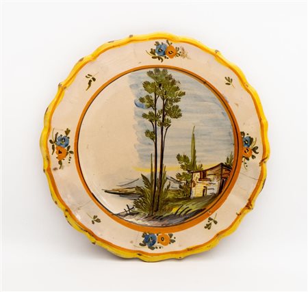 Piatto a bordo mistilineo con decoro a paesaggio nel cavetto e a fiori in quattro riserve alla tesa   Manifattura di Castelli del XX secolo