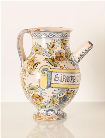 Orcio da farmacia decorato con girali fioriti e con cartiglio indicante denominazione del farmaco contenuto iManifattura laziale della fine del XVII secolo e gli inizi del XVIII secolo.   