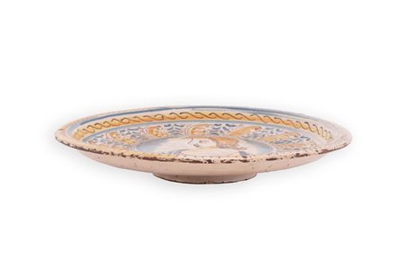 Alzata in maiolica decorata in policromia nello stile compendiario con al centro raffigurato un busto femminile.   Manifattura di Bussi sul Tirino del XVII secolo