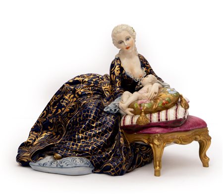 Statuina raffigurante madre con sontuoso abito blu e oro che allatta al seno il suo bambino adagiato su cuscini posti su un sofa   Luigi Fabris
