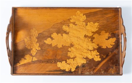 Émile Gallé (1846-1904), Francia. Vassoio rettangolare in legno, a due impugnature con intarsi in legno di frutto che disegnano un paesaggio con alberi e colline, firmato Gallé.