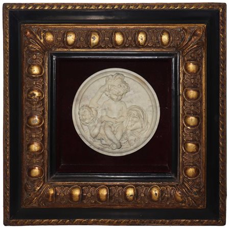 Bassorillievo ovale raffigurante gioco di putti in cornice dorata