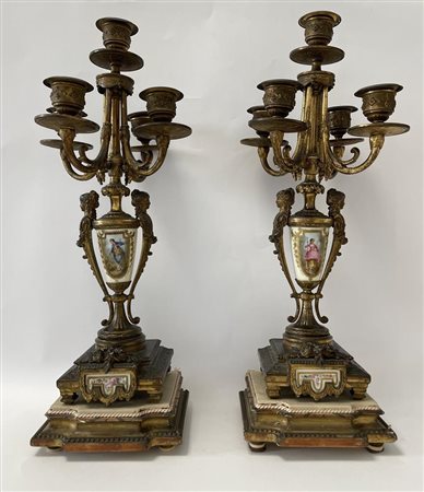 Coppia di candelabri a cinque fuochi in bronzo dorato finemente cesellato con figure muliebri a rilievo Base quadrata mistilinea.    