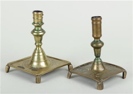 A lot of two Spanish brass candlesticks on a square base and legs, 17th/18th...