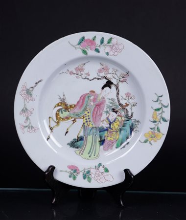 A porcelain Famille rose plate decorated with two figures and a ruby red...