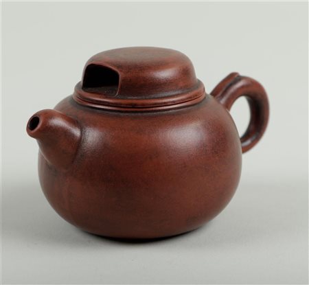 A Yixing teapot, marked on the urn, handle and inside of lid. China, circa...