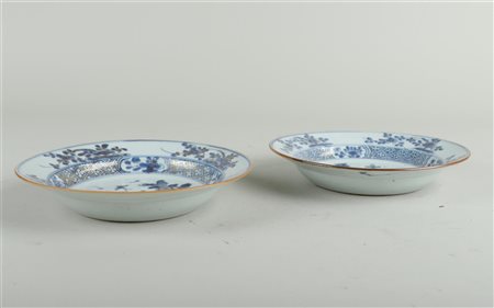 A set of two porcelain plates with floral decoration and gold-worked...