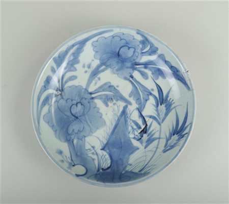A deep porcelain dish with flooral decoration. China, Ming. Hairlines.Diam....