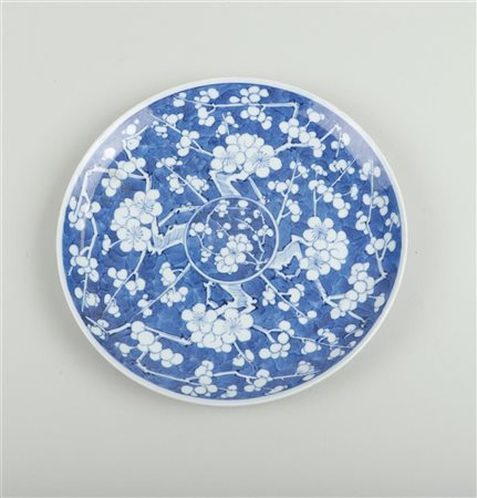 A porcelain plate with prunus decoration. China, 19th century.Diam. 21 cm.
