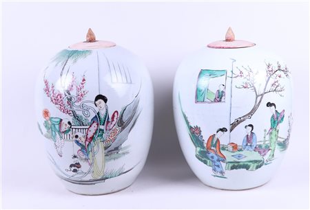 Two porcelain storage jars with floral decor of figures in a garden.H. 29 cm.