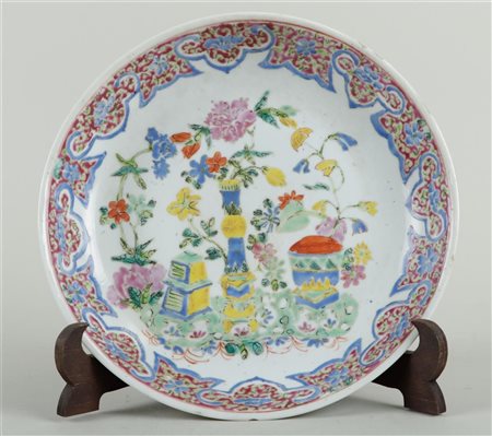 A Famille Rose dish decorated with flowers and antiques.Diam. 24 cm.