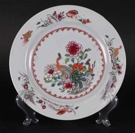 A porcelain Famille Rose plate with two peacocks in rich floral decoration,...