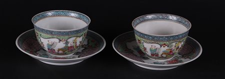 Two porcelain cups and saucers with rich figural decoration in borders. After...