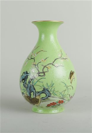 A porcelain green glazed and worked vase with decoration of blossoming...