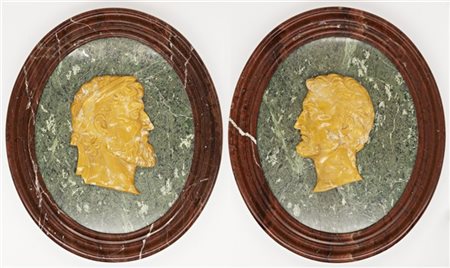 Coppia di medaglioni ovali in marmi vari con profili maschili classici barbuti