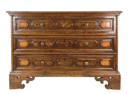 Cassettone in noce con fronte a tre cassetti decorati da bugne, piedi a mensola