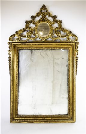 Specchiera in legno intagliato e dorato con cimasa a volute intrecciate centrat