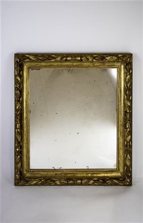 Specchiera con cornice in legno intagliato e dorato a foglie e nastri. Secolo X