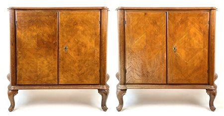 Coppia di credenze di forma mossa lastronate in noce, fronte a due ante e piedi