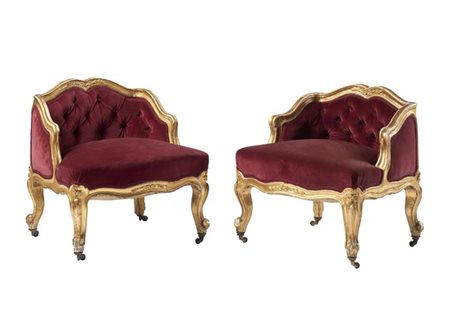 Coppia di basse poltrone di forma mossa in legno intagliato e dorato, schienale