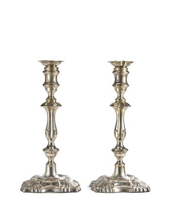 Coppia di candelieri in argento con corpo scanalato e decorato a volute, basi s
