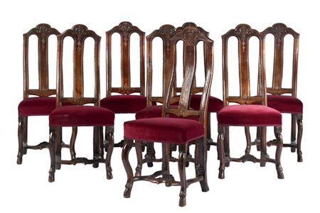 Gruppo di otto sedie in noce con alto schienale e cimasa decorata da rilievo a