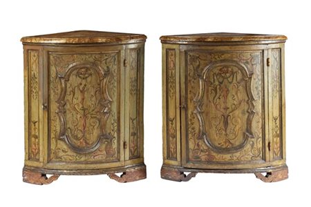 Coppia di cantonali in legno dipinto, laccato e dorato, fronte ad un’anta con r