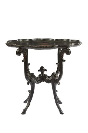 Tavolo in legno ebanizzato ed intagliato con piano laccato e decorato da volati