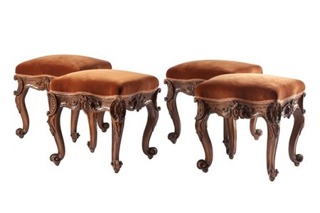 Gruppo di quattro sgabelli in noce intagliato a volute e motivo a rocaille, pie