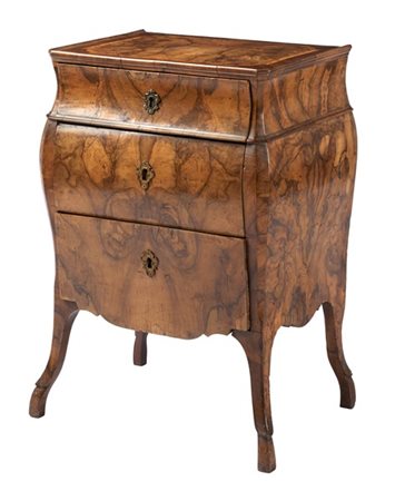 Comodino di forma mossa lastronato in radica di noce con fronte a tre cassetti,