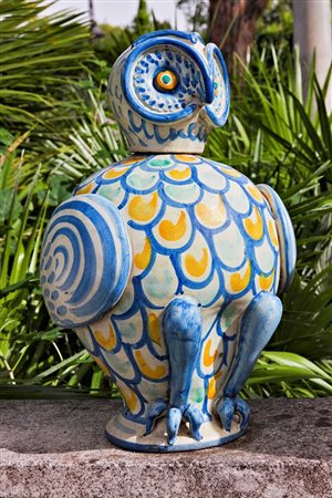 Bottiglia in ceramica smaltata nei toni del giallo, verde e blu raffigurante civetta   