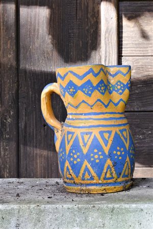 Piccola brocca ridipinta nei colori del giallo e dell'azzurro con figure geometriche   
