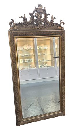 A large facet cut mirror, crest decorated with puti.170 x 60 cm.