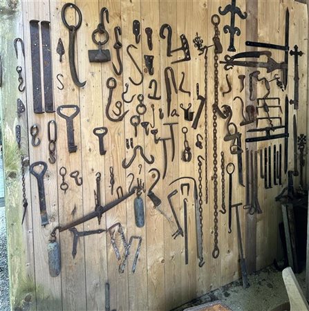 A large collection of wrought iron hooks and fittings.
