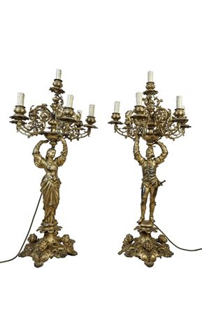 Coppia di candelabri a sette luci in metallo dorato con fusto a figure reggenti
