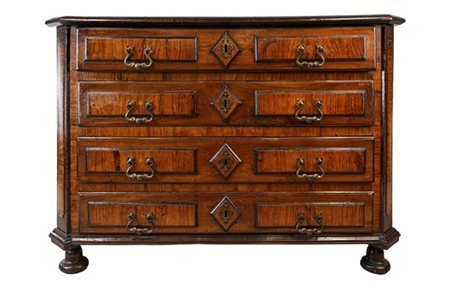 Cassettone scantonato in noce con fronte a quattro cassetti decorati a rilievo